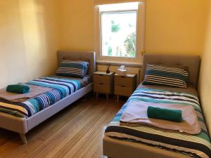 德文港Riverbank villa的小型客房 - 带2张床和窗户