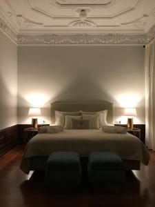 科英布拉Oryza Guest House& Suites的一间卧室配有一张大床和两盏灯
