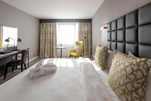 布鲁塞尔布鲁塞尔格雷西姆贝尔森酒店的酒店客房设有一张白色大床和书桌