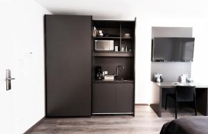曼海姆Mood contemporary living的一间设有一张桌子和一台电视的黑色隔板的房间