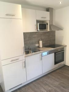 阿布特瑙吉桑德公寓的厨房配有白色橱柜、水槽和微波炉