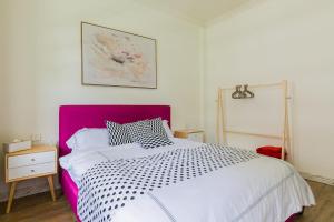 海口海口市美兰区·南大桥泰龙城·路客精品公寓·00159630的一间卧室配有一张大床和紫色床头板