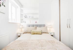 伦敦Bright & Modern 2-Bed Notting Hill Apartment的一间白色卧室,配有床和2个床头柜