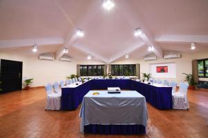 普里Toshali Sands Puri的大房间设有蓝色的桌子和白色的椅子