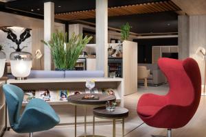 马德里卡斯蒂利亚美利亚酒店的大堂配有五颜六色的椅子和桌子