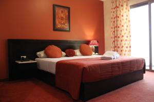 朱尼耶日出酒店的一间卧室配有一张带枕头和桌子的床