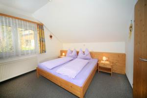 Liebenfels克奈伯格尔霍夫农场假期酒店的一间卧室配有一张带紫色枕头的床和窗户。
