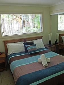 阿沃卡海滩阿沃卡棕榈树酒店的一间卧室配有一张大床和两条毛巾