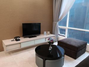 吉隆坡ML（SM）舒适公寓 的客厅配有平面电视和桌子。