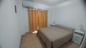 圣胡安Departamento en pleno centro de San Juan的一间卧室配有床和橙色窗帘