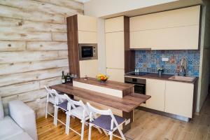 索非亚Sofia Central Luxury Apartment的厨房配有木桌和白色椅子