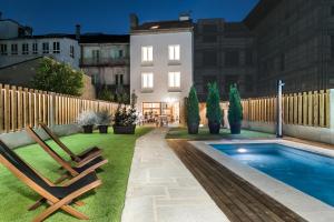 卡尔达斯·德·雷斯Hotel Pousada Real的后院设有两把椅子和游泳池