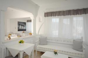 米克诺斯城米莱纳酒店的白色的客房配有白色的桌椅和镜子