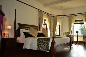 努沃勒埃利耶山丘度假屋的卧室配有一张带白色床单和枕头的大床。