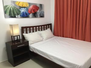 达沃市博尔德甜蜜之家公寓的一间卧室配有一张床和一个带遮阳伞的床头柜。
