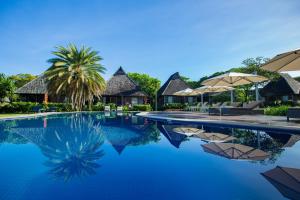 辛加东卡Yatule Resort & Spa的度假村的游泳池,配有椅子和遮阳伞