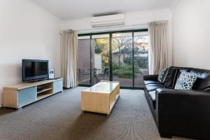 珀斯Perth Ascot Central Apartment Hotel Official的带沙发和电视的客厅