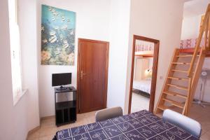 里奥马里纳Appartamenti Sole e Luna的一间设有桌子、床和梯子的房间