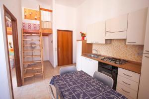 里奥马里纳Appartamenti Sole e Luna的厨房配有白色橱柜和桌椅