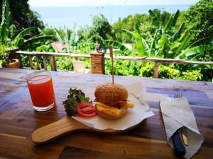 莱利海滩Blanco Hideout Railay - Youth Hostel 18 to 35 Only的木桌上的三明治和一杯果汁