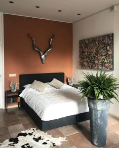 莱顿De Pelgrimsplaats的一间卧室配有床,墙上有鹿角