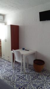 兰佩杜萨Blue Bab B&B的客房铺有瓷砖地板,配有白色的桌椅。