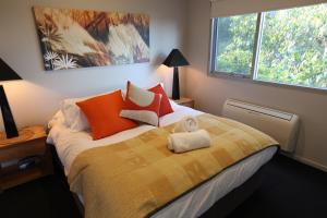 洛恩洛恩豪华度假屋的一间卧室配有一张黄色和橙色毯子的床