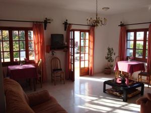 斯塔罗斯安妮科公寓式酒店的客厅设有两张桌子和红色窗帘