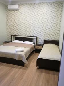 克瓦雷利Guest House Kakheti的一间卧室设有两张床和一堵墙