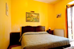 韦尔巴尼亚蒙特罗索农家乐的卧室配有一张黄色墙壁上的床