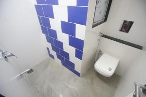 孟买Mumbai Staytion Dorm- Hostel的浴室设有蓝色和白色瓷砖,配有卫生间