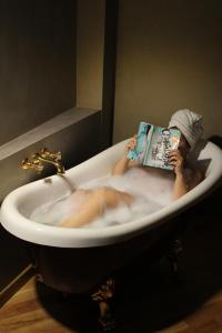 特拉帕尼Appartamenti Trapani In的坐在浴缸里读书的人