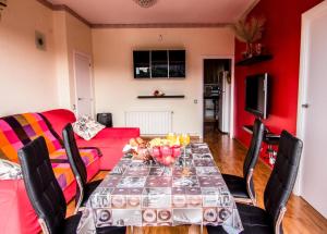巴塞罗那独特舒适景观阁楼公寓的一间带桌子和红色沙发的用餐室