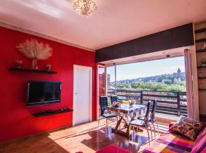 巴塞罗那独特舒适景观阁楼公寓的客厅设有红色的墙壁和桌椅