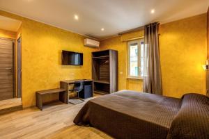 罗马奥斯玛尔酒店的一间卧室设有黄色的墙壁、一张床和电视