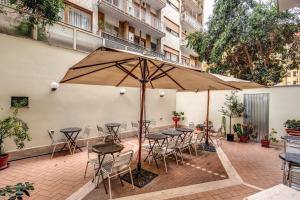 罗马奥斯玛尔酒店的一个带桌椅和遮阳伞的庭院