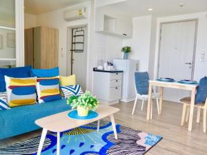 华欣Summer Huahin712,Side sea view,Near Beach&Cicada,Beautiful Swimming pool的客厅配有蓝色的沙发和桌子