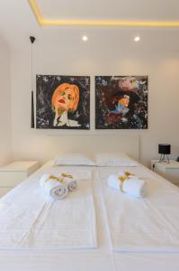 贝尔格莱德Sava Smart Apartment的卧室配有两张白色床,墙上挂有艺术品