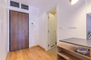 贝尔格莱德Sava Smart Apartment的厨房设有白色的墙壁和木门。
