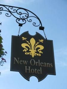 尤里卡斯普林斯New Orleans Hotel Eureka Springs的挂在钩子上的新建或新奥尔良酒店的标志