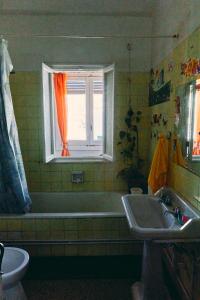 得土安Tetouan house的带浴缸、水槽和窗户的浴室