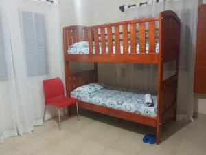 恩德培Wemofa Pad Self-Catering Apartment的一间卧室设有两张双层床和一张红色椅子
