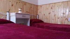 布兰卡港Hospedaje La Serranita的紫色床单的客房内的两张床