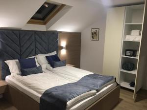 普里什蒂纳Sleep Inn Prishtina的一间卧室配有一张带蓝色枕头的大床