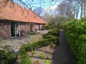 Zuidbroek尤特伯伦住宿加早餐旅馆的砖屋前的花园