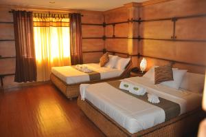 安蒂波洛Bosay Resort的一间卧室设有两张床和窗户。
