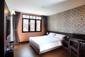 曼谷Rambuttri Village Plaza - SHA Extra Plus的一间卧室设有一张大床和一个窗户。