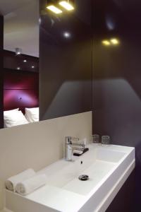 阿斯米尔蓝宅酒店的浴室设有白色水槽和镜子