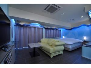 神户Hotel ShaSha Resort Suma的一间卧室配有一张床、一张沙发和一台电视