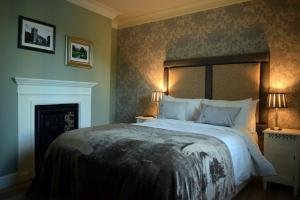 索尔兹伯里灰狗威尔顿宾馆的一间卧室配有一张大床和两盏灯。